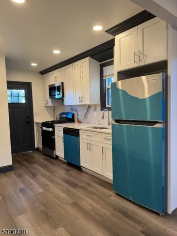 a kitchen with a sink a refrigerator and cabinets
