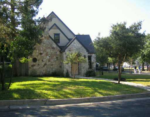 a view of a big house with a big yard and large trees