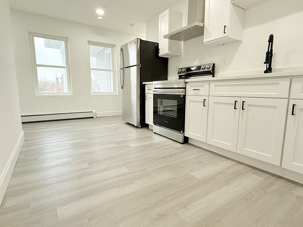 23 Bellevue Street, Unit 3 Worcester, MA 01609 - Photo 12 of 26 a kitchen with stainless steel appliances granite countertop a stove a sink and a refrigerator