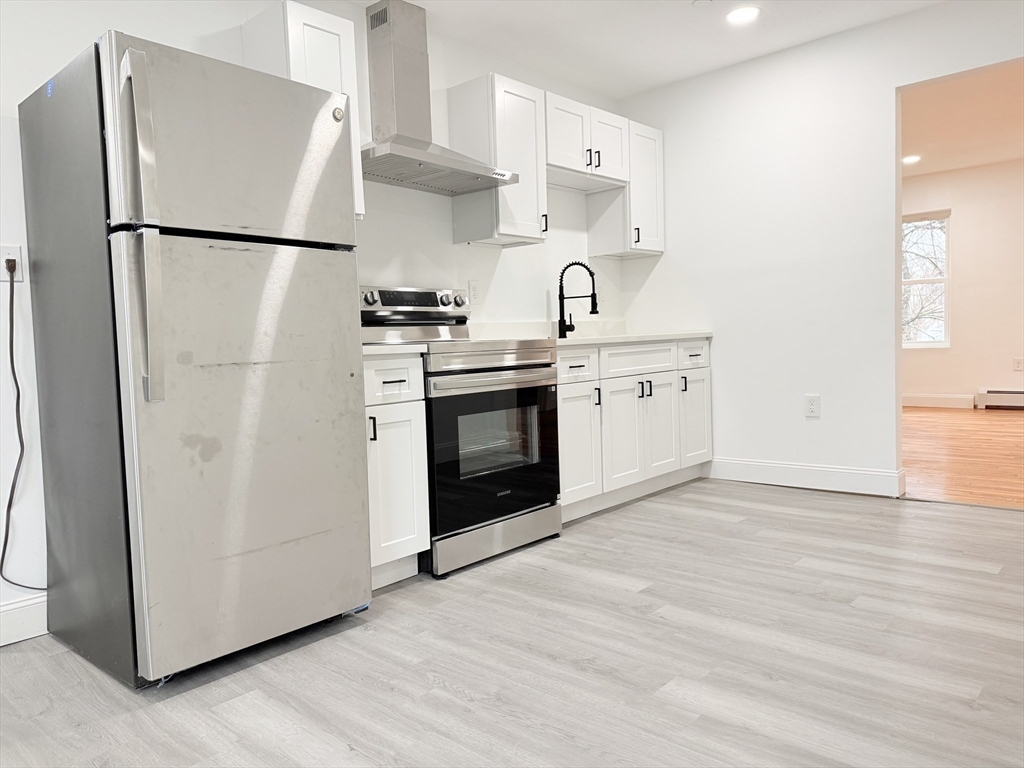 23 Bellevue Street, Unit 3 Worcester, MA 01609 - Photo 14 of 26 a kitchen with stainless steel appliances a refrigerator a sink and white cabinets