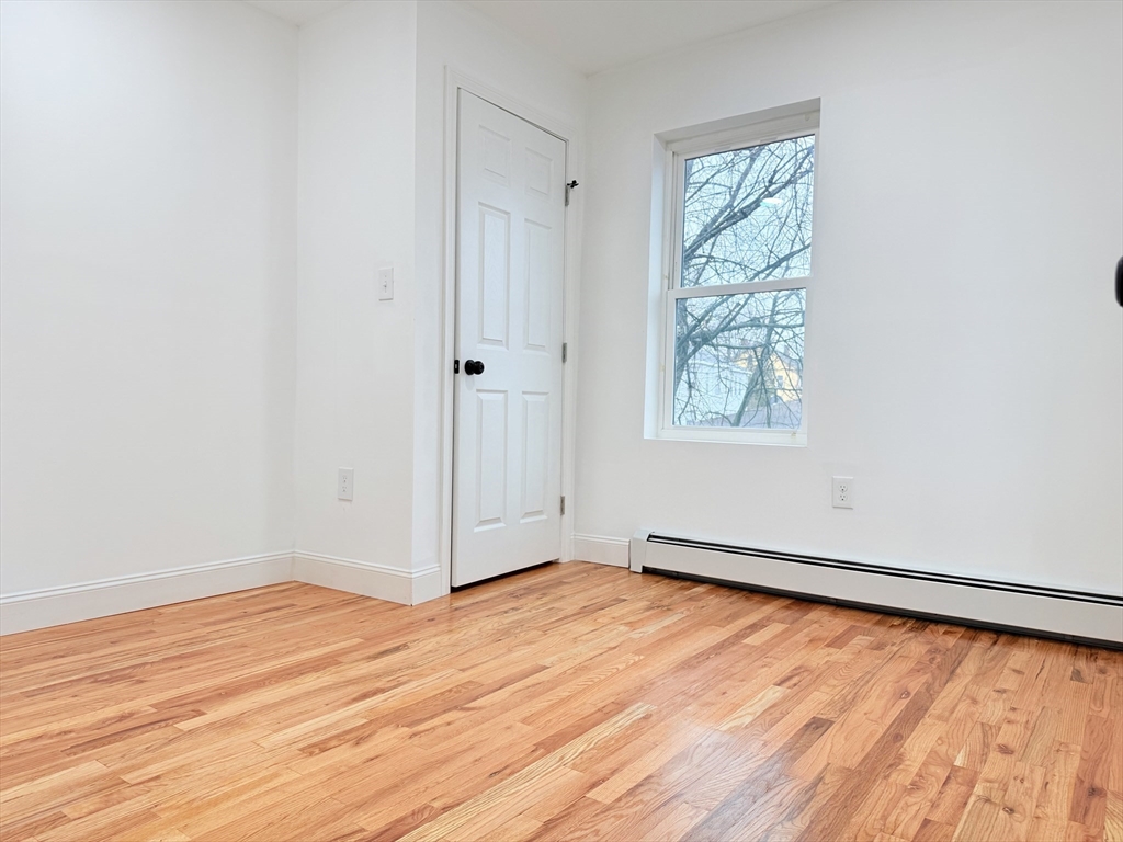 23 Bellevue Street, Unit 3 Worcester, MA 01609 - Photo 20 of 26 an empty room with wooden floor and windows