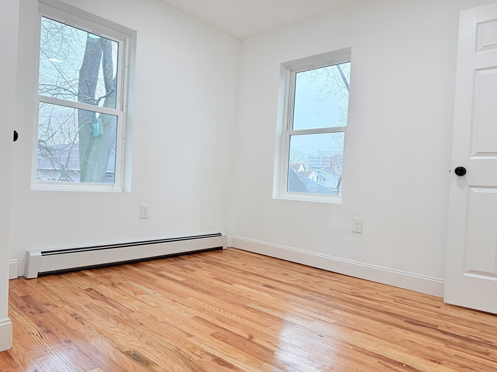 23 Bellevue Street, Unit 3 Worcester, MA 01609 - Photo 21 of 26 an empty room with wooden floor and windows