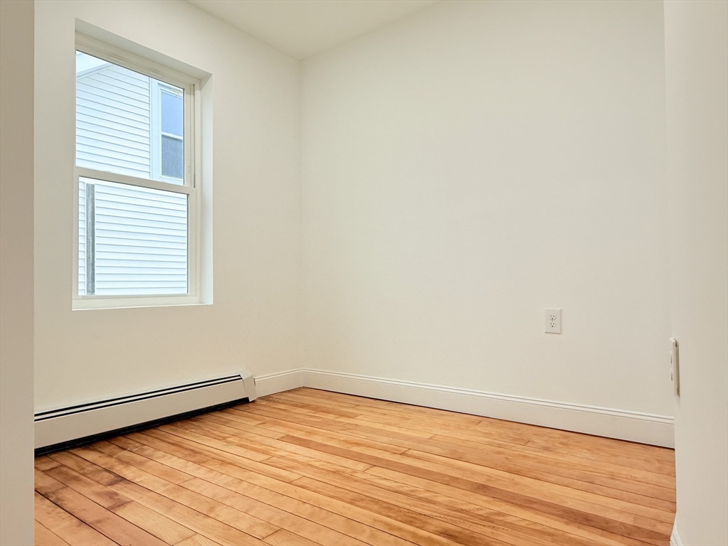 23 Bellevue Street, Unit 3 Worcester, MA 01609 - Photo 22 of 26 an empty room with wooden floor and windows