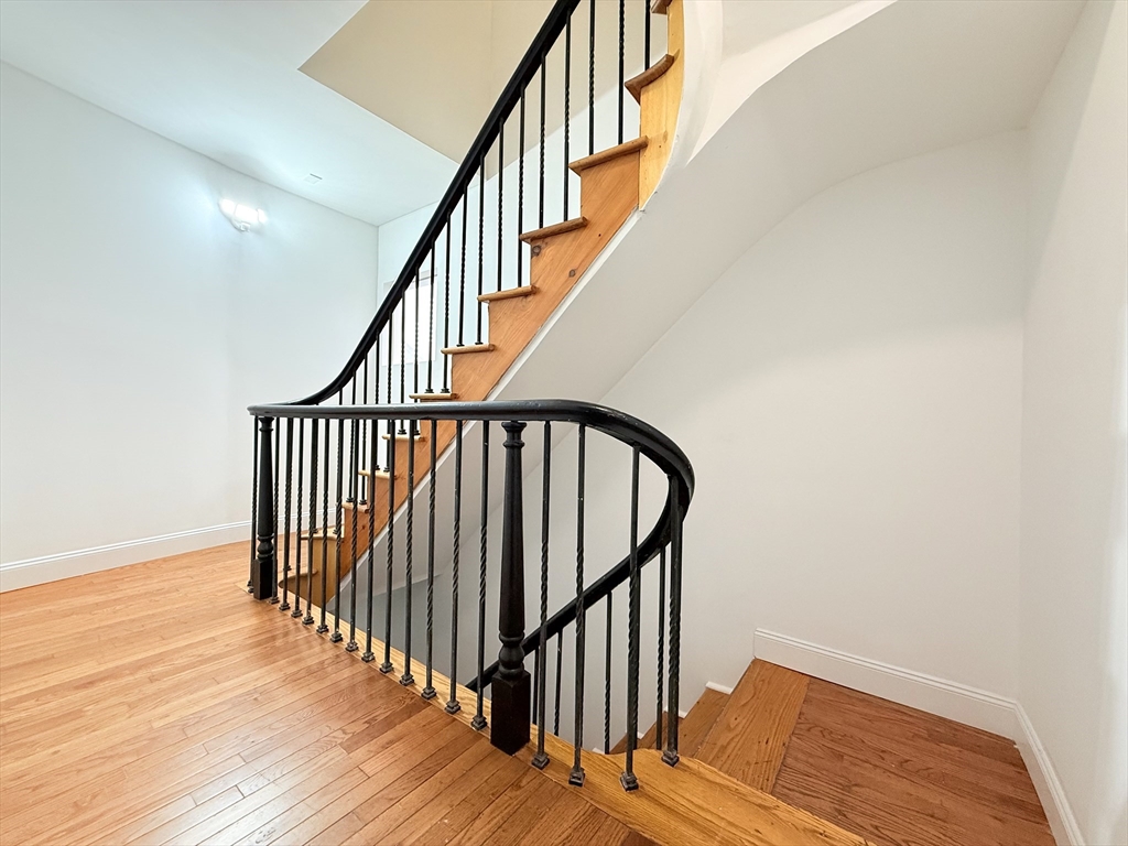 23 Bellevue Street, Unit 3 Worcester, MA 01609 - Photo 4 of 26 a view of staircase with railing and white walls
