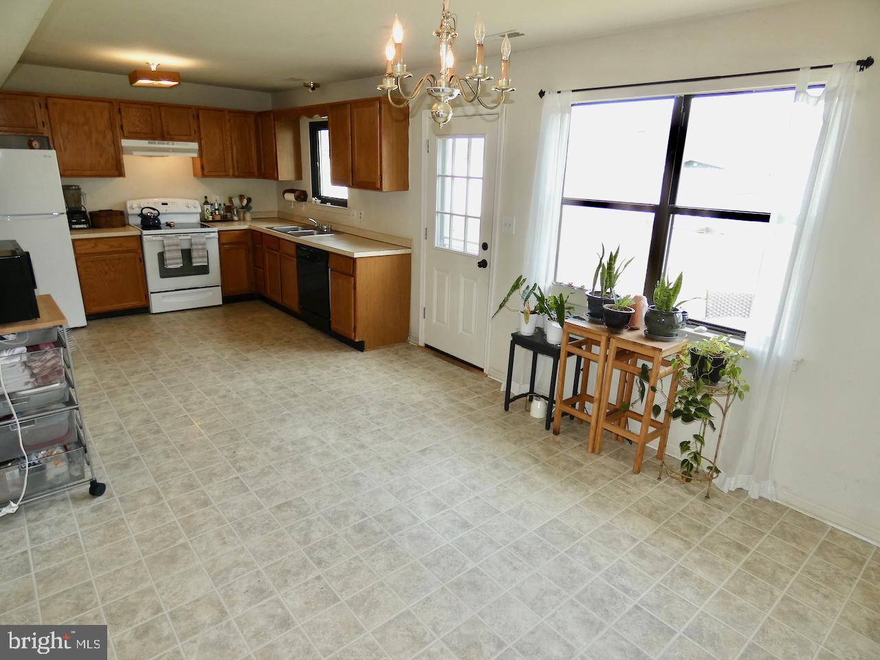 5 Acapella Court Newark, DE 19713 - Photo 14 of 68 a kitchen with stainless steel appliances granite countertop a stove top oven a sink a dining table and chairs with the view of kitchen
