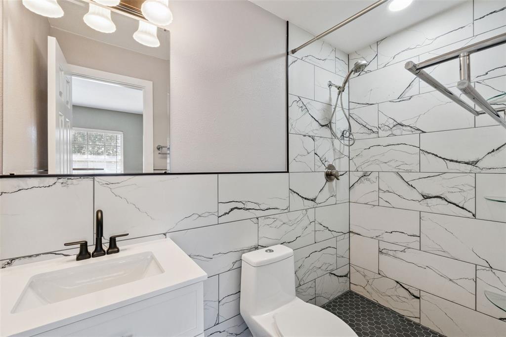 2613 East Church Street Orlando, FL 32803 - Photo 13 of 32 a bathroom with a sink mirror vanity and toilet