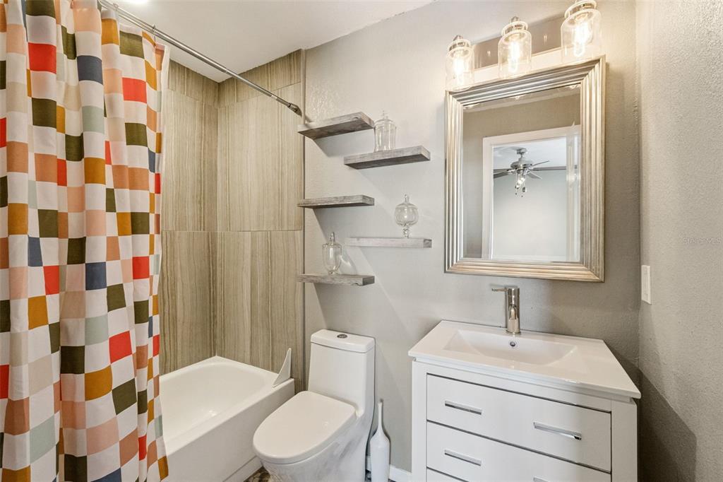 2613 East Church Street Orlando, FL 32803 - Photo 16 of 32 a bathroom with a sink toilet a mirror and shower curtain