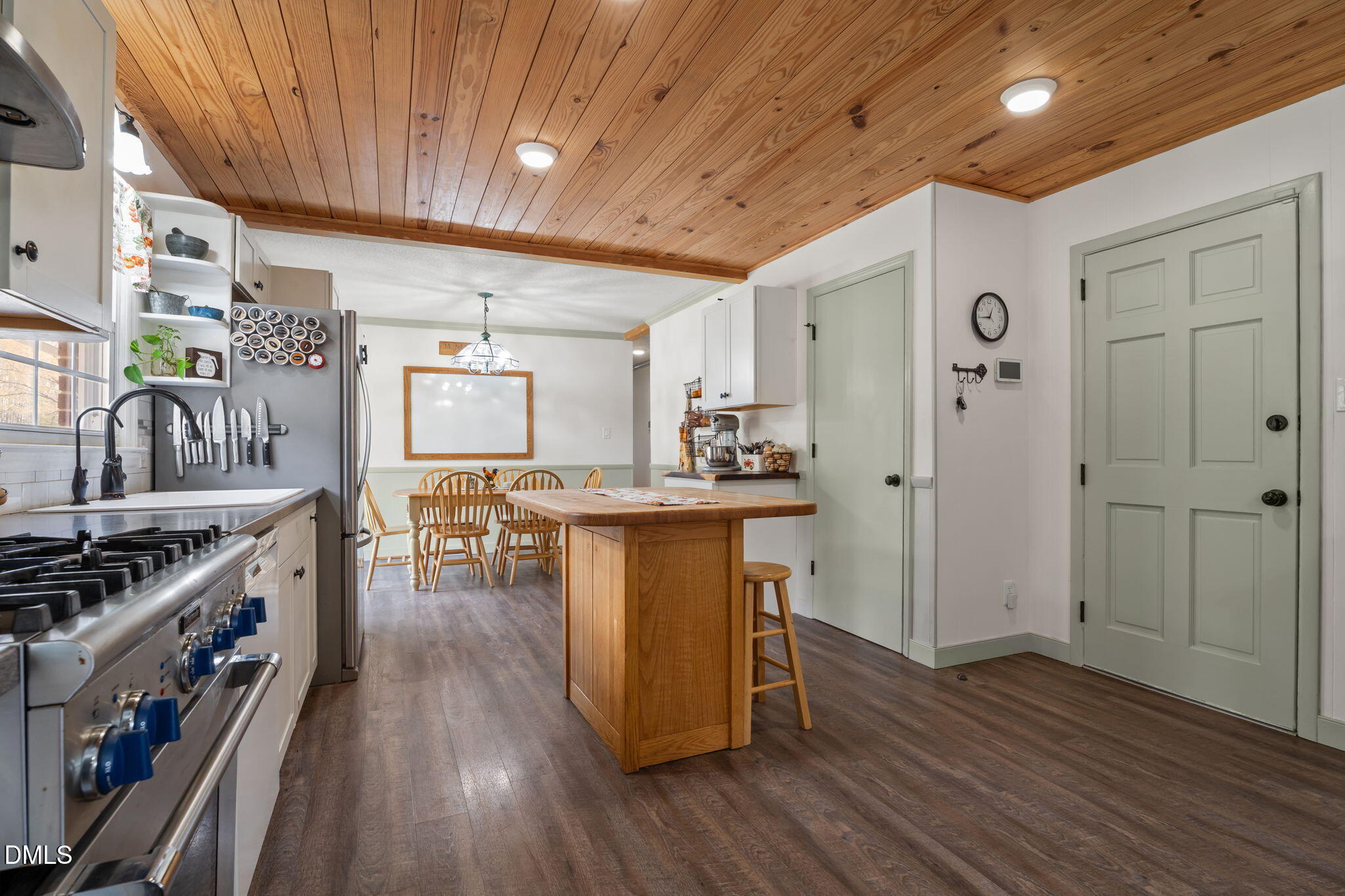 4313 Mitchell Mill Road Wake Forest, NC 27587 - Photo 8 of 45 a kitchen with stainless steel appliances a stove a refrigerator a sink dishwasher and a dining table with wooden floor