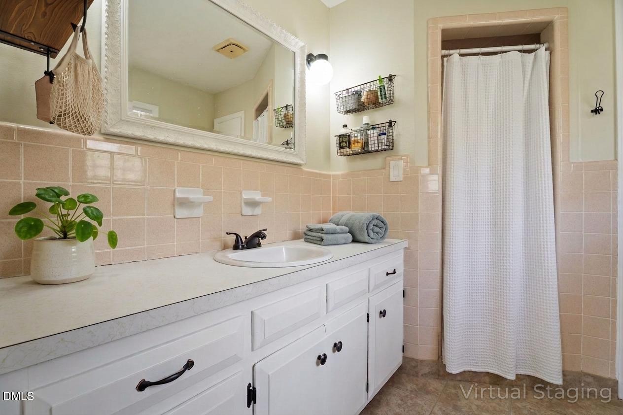 4313 Mitchell Mill Road Wake Forest, NC 27587 - Photo 25 of 45 a bathroom with a sink a mirror and a potted plant