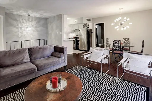 a living room with furniture a rug and a chandelier