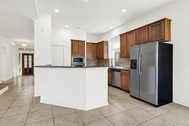 a kitchen with stainless steel appliances granite countertop a refrigerator and a sink