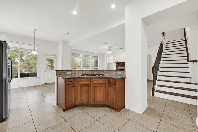 a kitchen with stainless steel appliances granite countertop a stove a sink dishwasher a refrigerator and a microwave