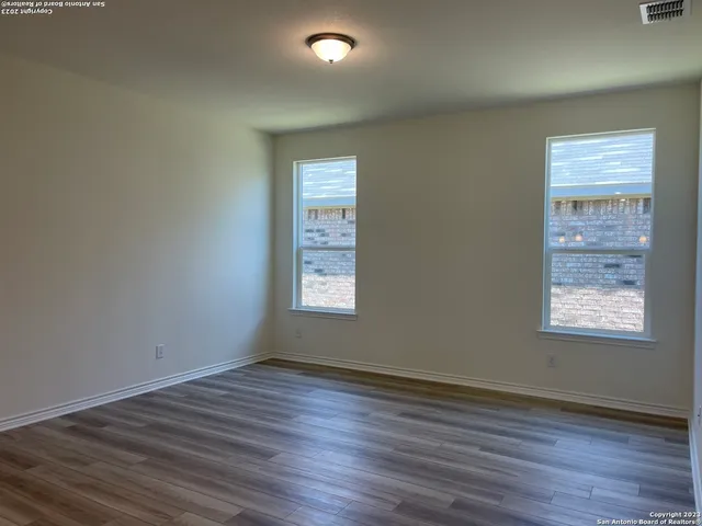 a large kitchen with white cabinets and a wooden floor