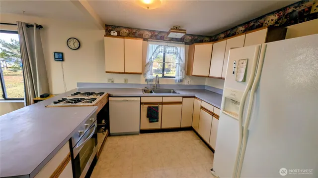 a kitchen with a white stove top oven sink and window