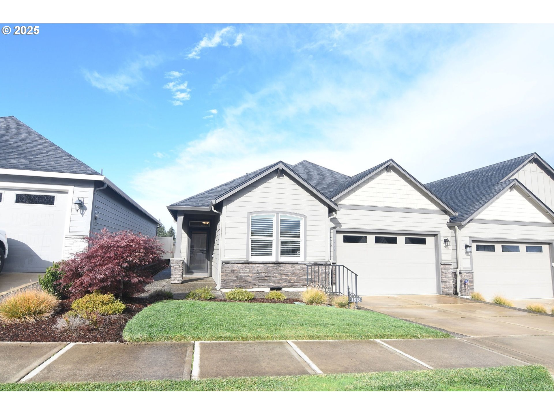 a view of a yard in front of a house with large windows