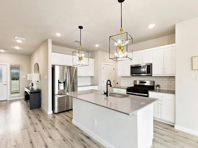 a kitchen with stainless steel appliances a kitchen island sink refrigerator and microwave