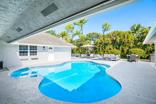 an aerial view of residential houses with outdoor space and swimming pool