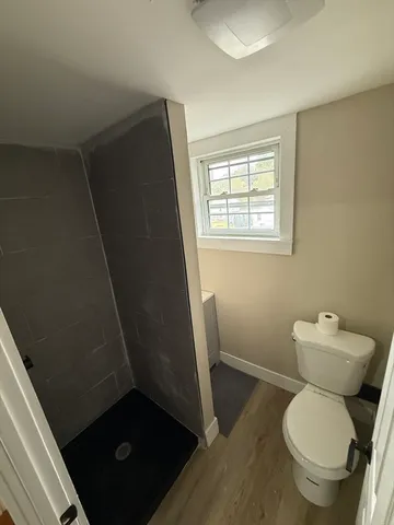a bathroom with a granite countertop toilet and a sink