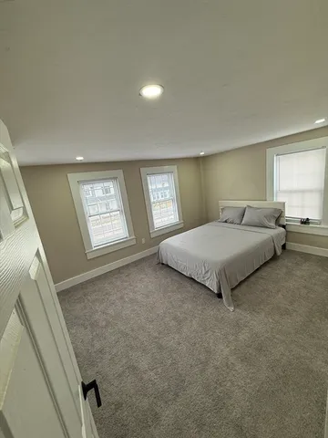a spacious bedroom with a bed and a window