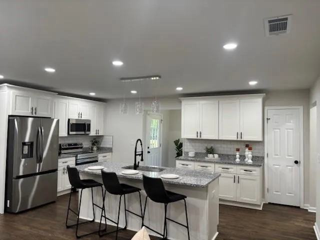 a kitchen with refrigerator and chairs
