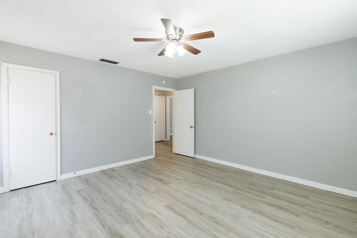 3605 26th Street Lubbock, TX 79410 - Photo 19 of 21 an empty room with wooden floor and ceiling fan