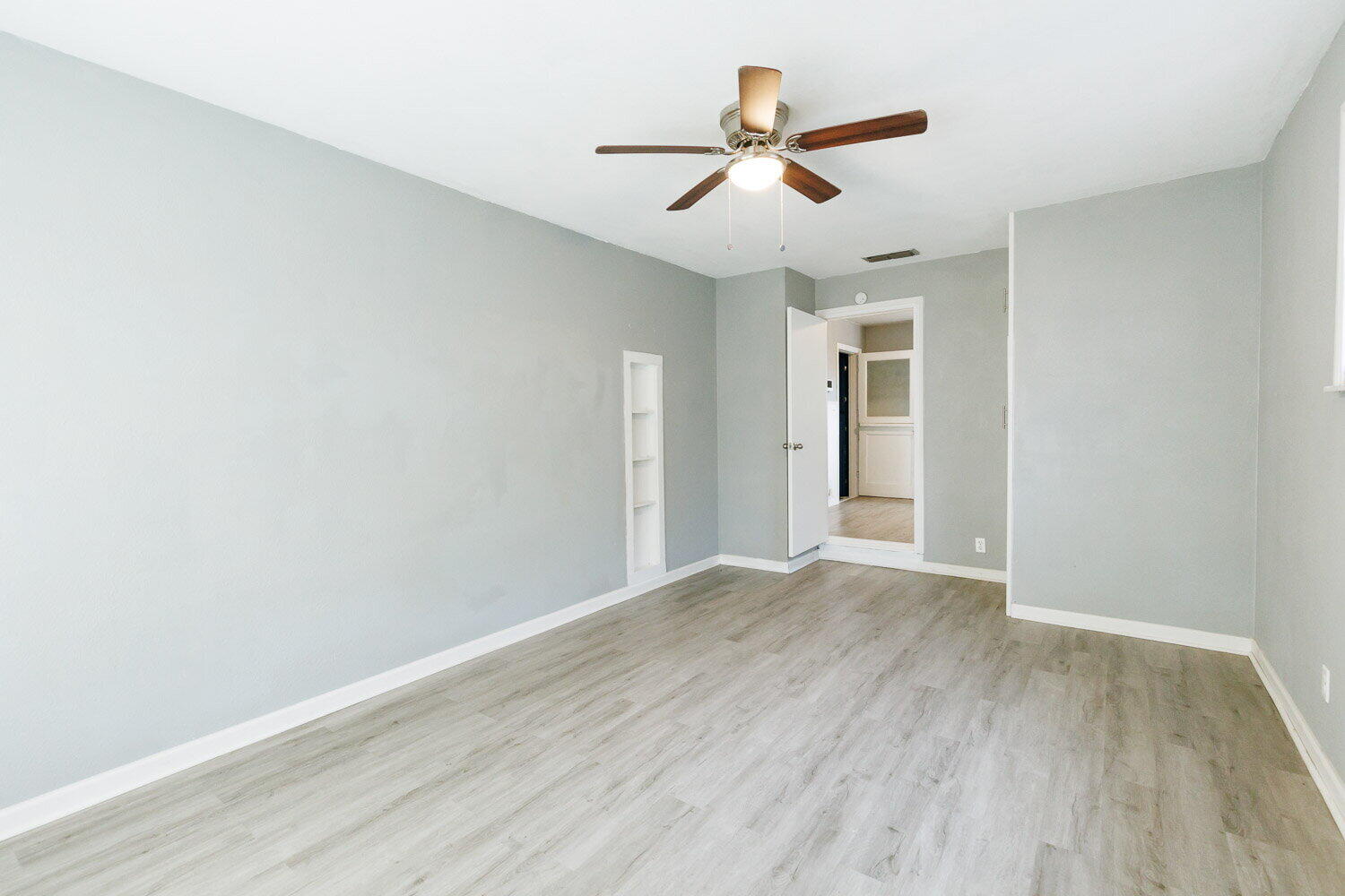 3605 26th Street Lubbock, TX 79410 - Photo 10 of 21 an empty room with wooden floor ceiling fan and window