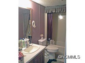 1027 Deep Gap Loop Road Flat Rock, NC 28731 - Photo 15 of 16 a bathroom with a granite countertop sink toilet and shower