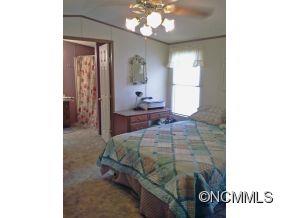 1027 Deep Gap Loop Road Flat Rock, NC 28731 - Photo 10 of 16 a bedroom with a bed and a chandelier