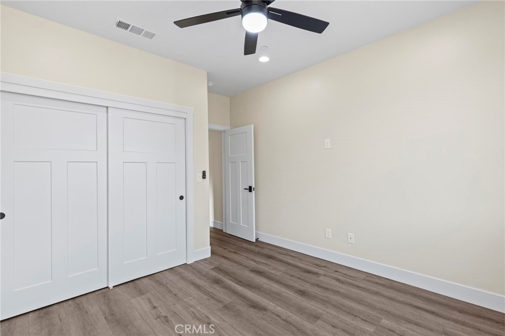 6148 Ripley Lane Paradise, CA 95969 - Photo 20 of 37 an empty room with wooden floor ceiling fan and windows