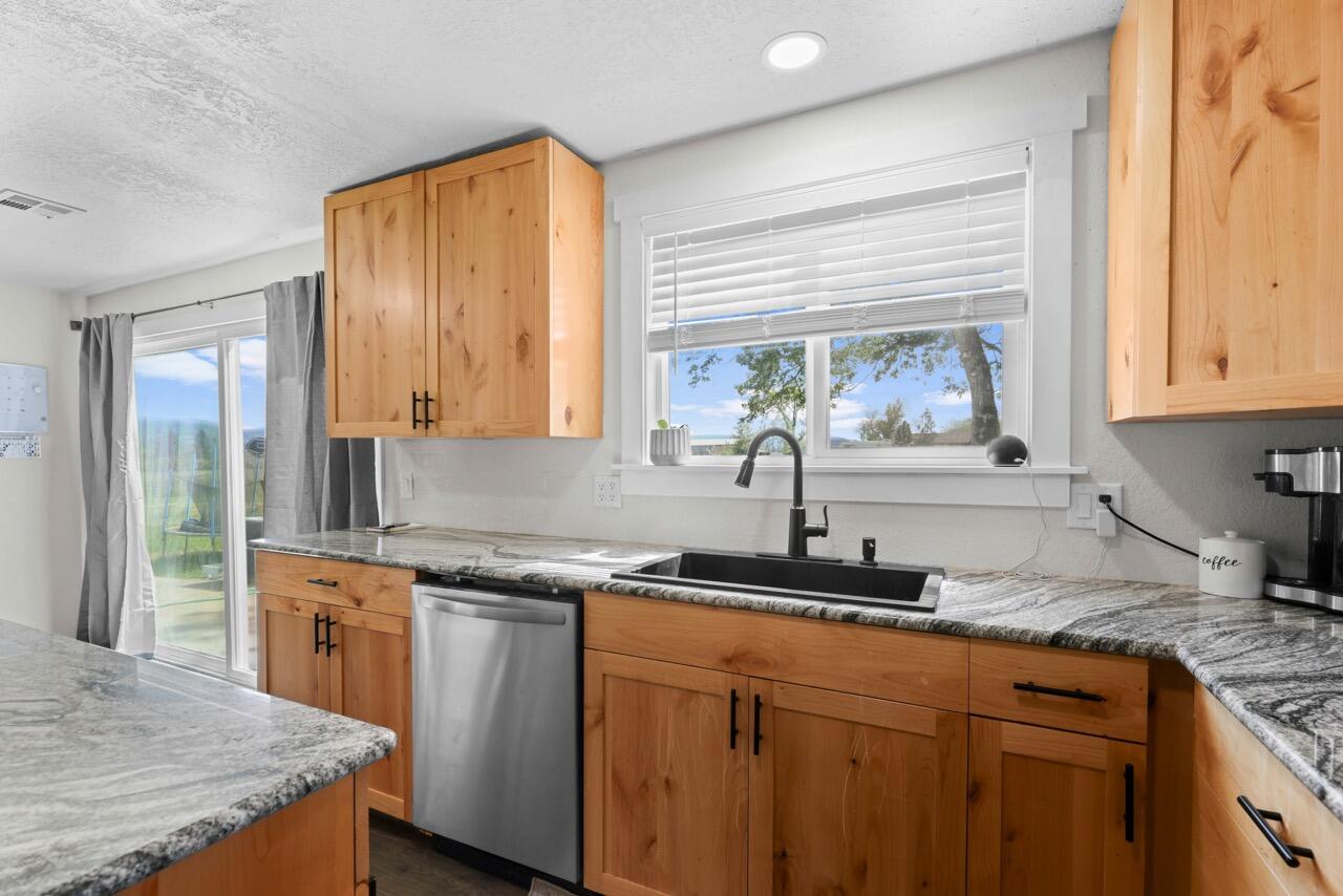 380 Greenleaf Drive Eagle Point, OR 97524 - Photo 14 of 31 a kitchen with stainless steel appliances granite countertop a sink stove and cabinets