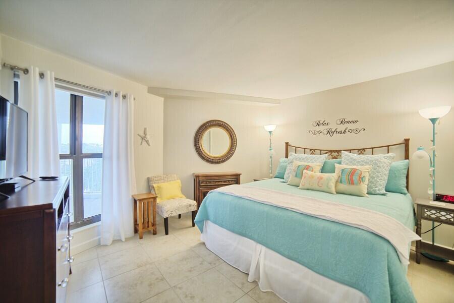 4239 Beachside 2, Unit 239 Miramar Beach, FL 32550 - Photo 13 of 18 a bedroom with a bed and a chandelier