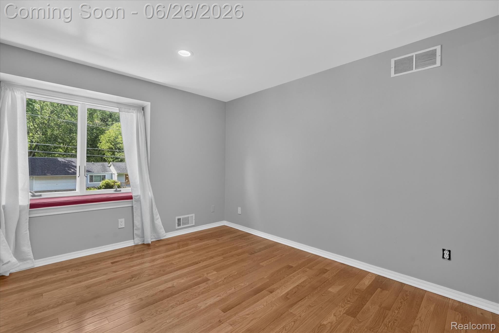 3478 Lexington Road Waterford, MI 48328 - Photo 22 of 52 Spacious room featuring wood-finish flooring, a large window with a built-in window seat, recessed ceiling lighting, and a white baseboard trim