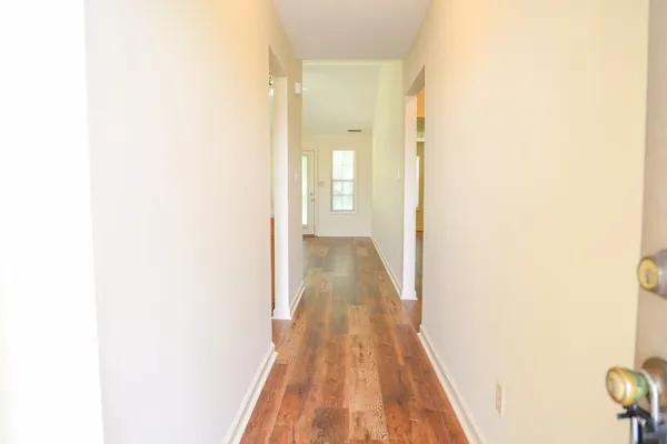 a view of a hallway with wooden floor