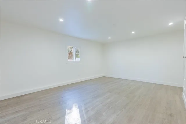 an empty room with wooden floor and a window