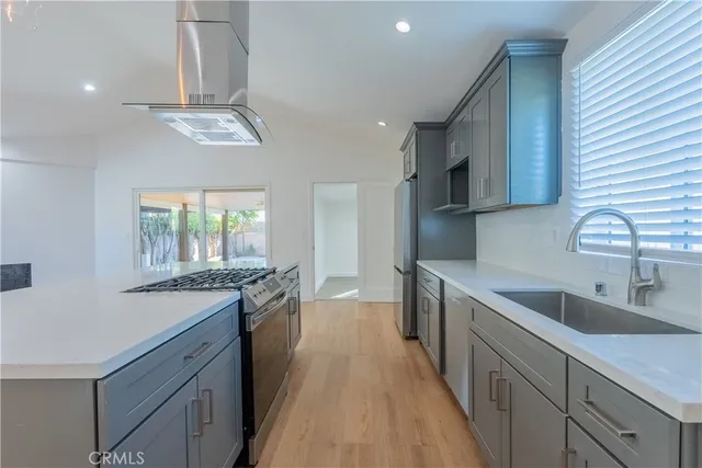 a kitchen with stainless steel appliances granite countertop a sink a stove top oven a counter space and cabinets