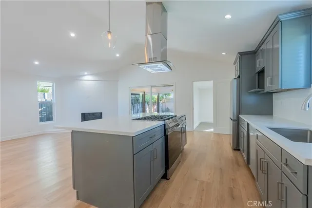 a kitchen with stainless steel appliances granite countertop a sink a stove and a wooden floors