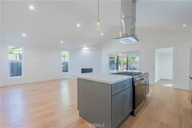 a kitchen with kitchen island granite countertop a sink and a stove