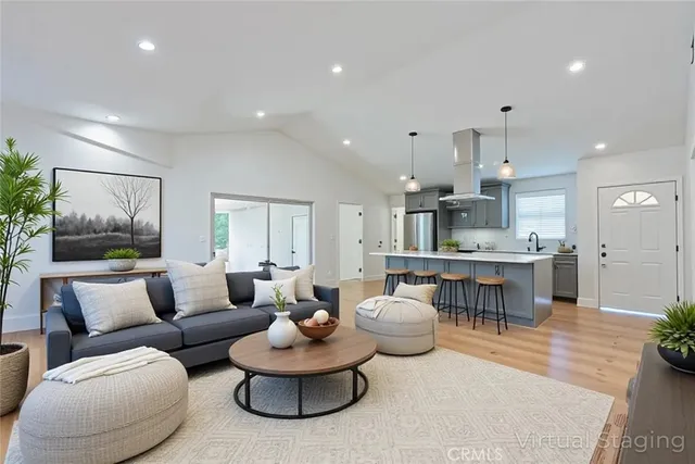 a living room with furniture and a view of kitchen