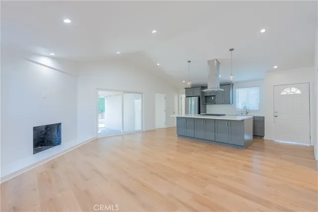 a large kitchen with stainless steel appliances a large counter top a stove and a sink