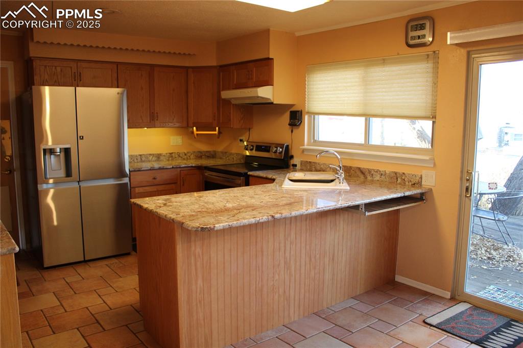 8340 Piute Road Colorado Springs, CO 80926 - Photo 17 of 48 a kitchen with stainless steel appliances granite countertop a refrigerator and a stove