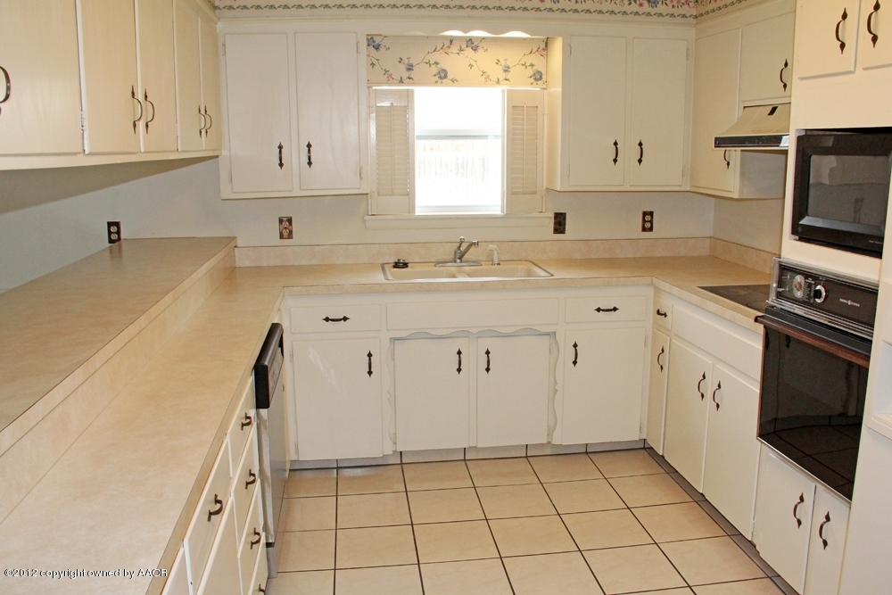7106 Jameson Road Amarillo, TX 79106 - Photo 3 of 33 a kitchen with a sink a stove and cabinets