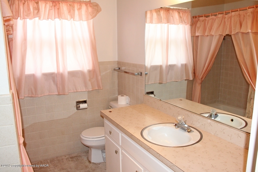 7106 Jameson Road Amarillo, TX 79106 - Photo 8 of 33 a bathroom with a granite countertop sink toilet a mirror and shower
