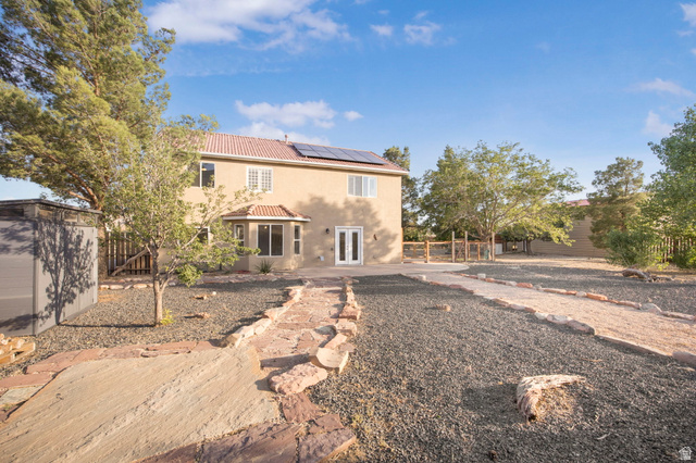 1440 West 100 South Virgin, UT 84779 - Photo 33 of 45 Spacious rear exterior featuring a neutral stucco facade, terracotta tile roof, and solar panels