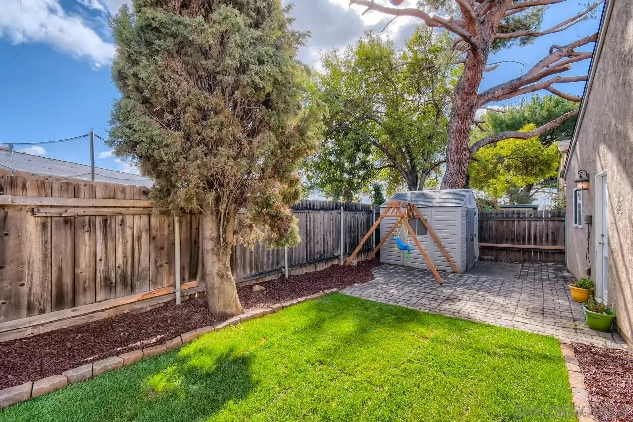 10023 Carreta Drive Santee, CA 92071 - Photo 22 of 24 a view of a backyard with a slide trees and wooden fence