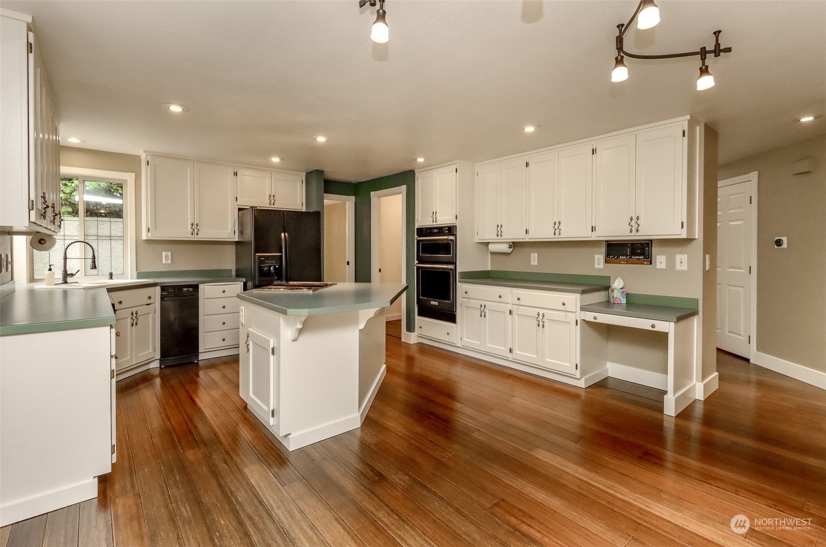 16918 Southeast 149th Street Renton, WA 98059 - Photo 11 of 40 an open kitchen with wooden floor and stainless steel appliances