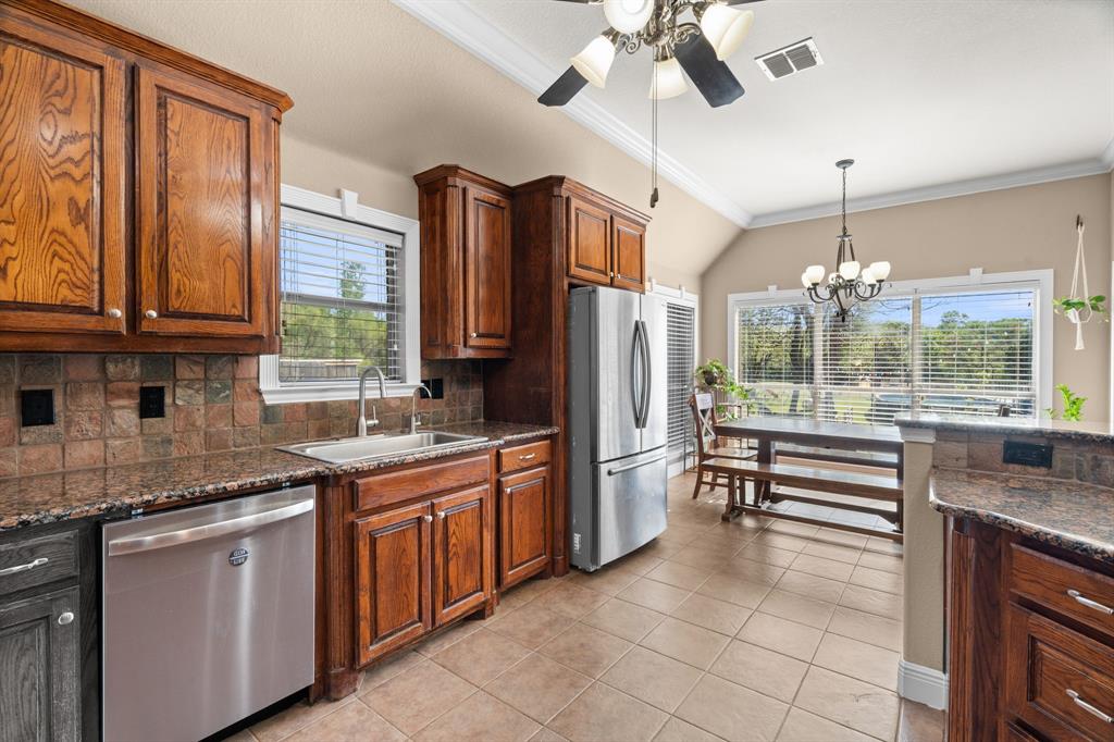 112 Waterfall Court Azle, TX 76020 - Photo 13 of 40 a kitchen with stainless steel appliances granite countertop a refrigerator and a sink