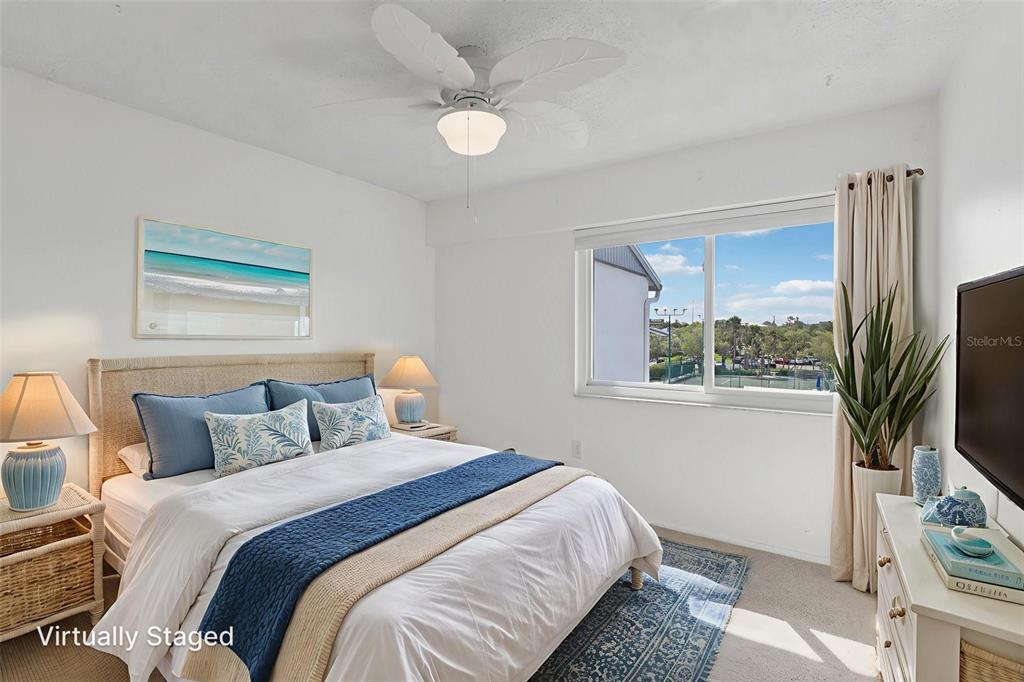 14800 Walsingham Road, Unit 1215 Largo, FL 33774 - Photo 26 of 34 a bedroom with a bed a flat screen tv and a large window