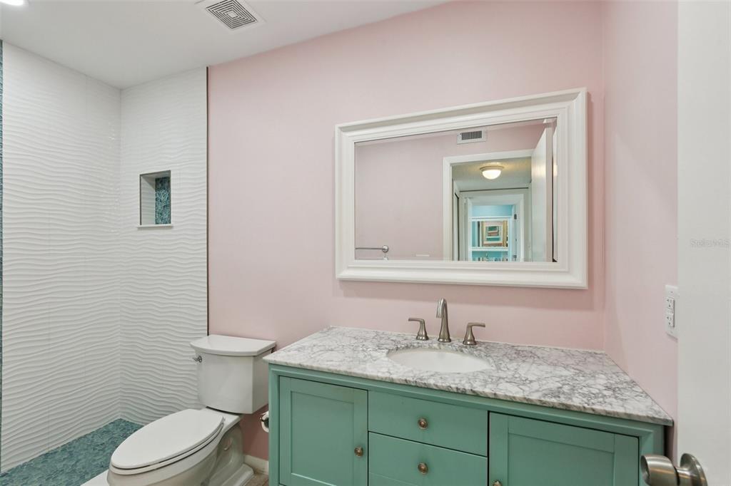 14800 Walsingham Road, Unit 1215 Largo, FL 33774 - Photo 28 of 34 a bathroom with a granite countertop toilet sink and mirror
