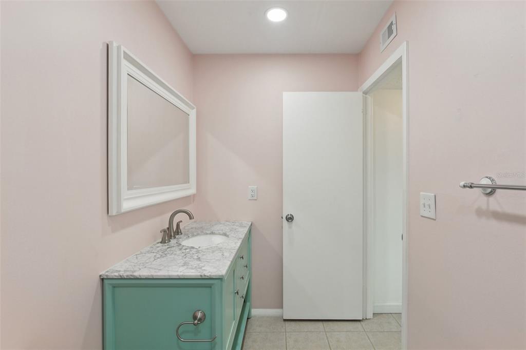 14800 Walsingham Road, Unit 1215 Largo, FL 33774 - Photo 29 of 34 a bathroom with a granite countertop sink and a mirror