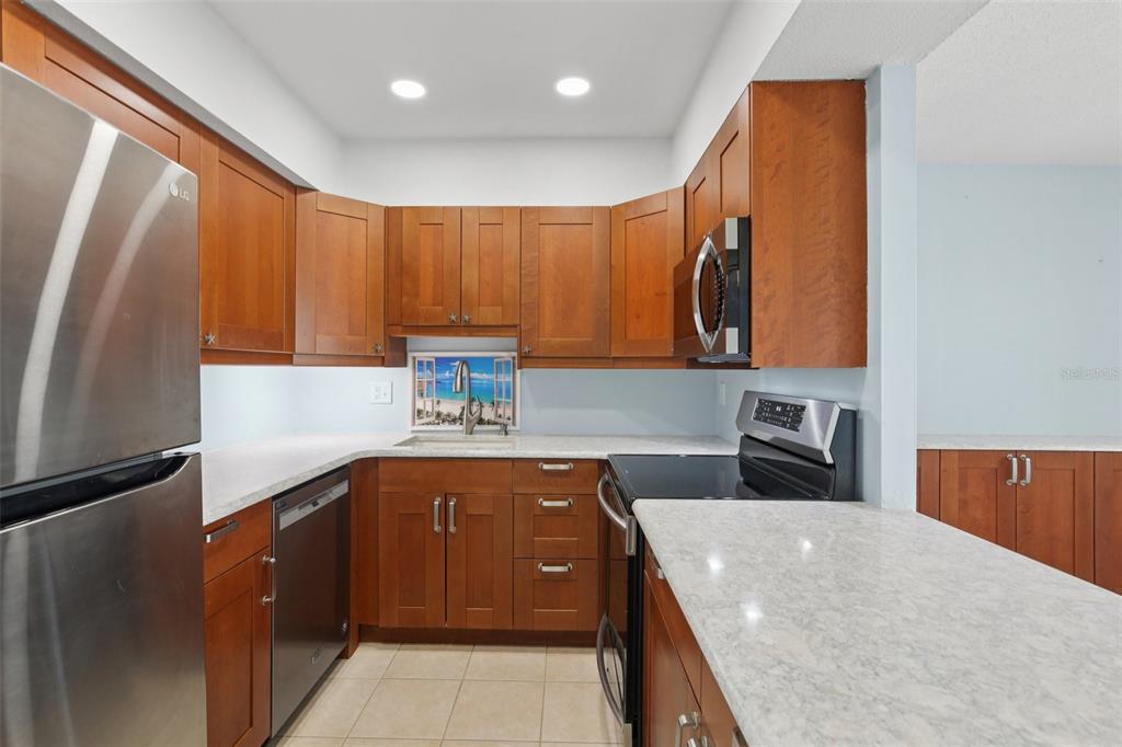 14800 Walsingham Road, Unit 1215 Largo, FL 33774 - Photo 4 of 34 a kitchen with stainless steel appliances granite countertop a sink stove and refrigerator